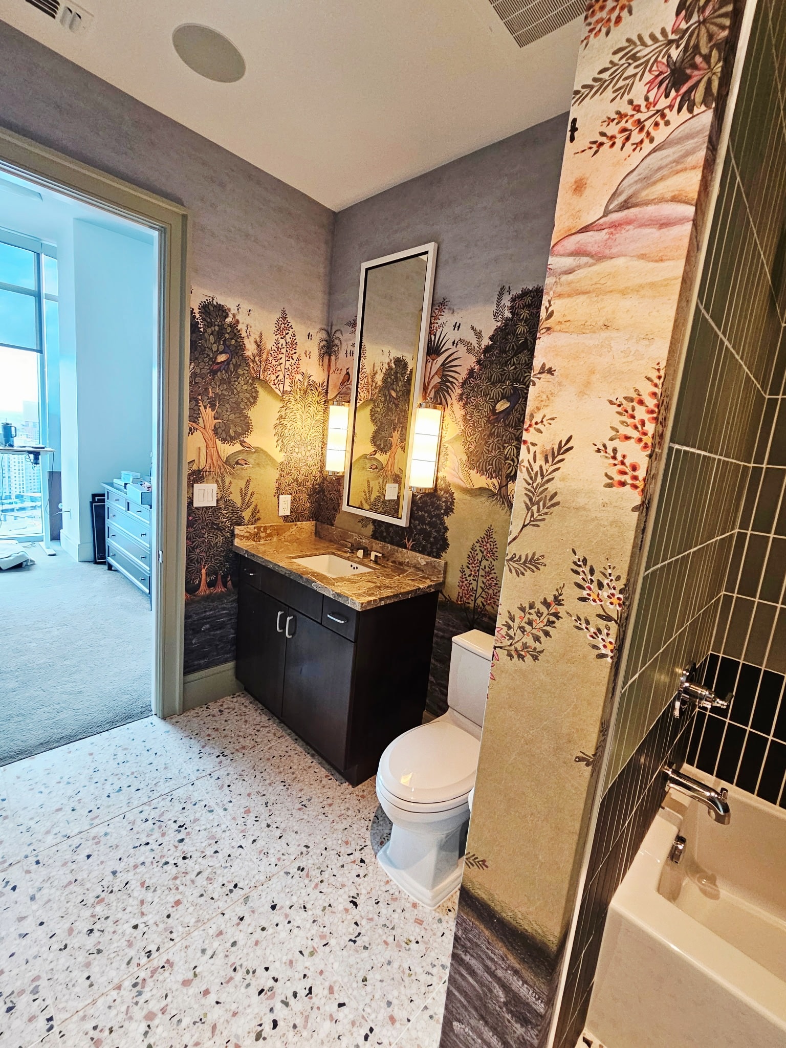 Custom bathroom renovation with botanical wallpaper and modern fixtures