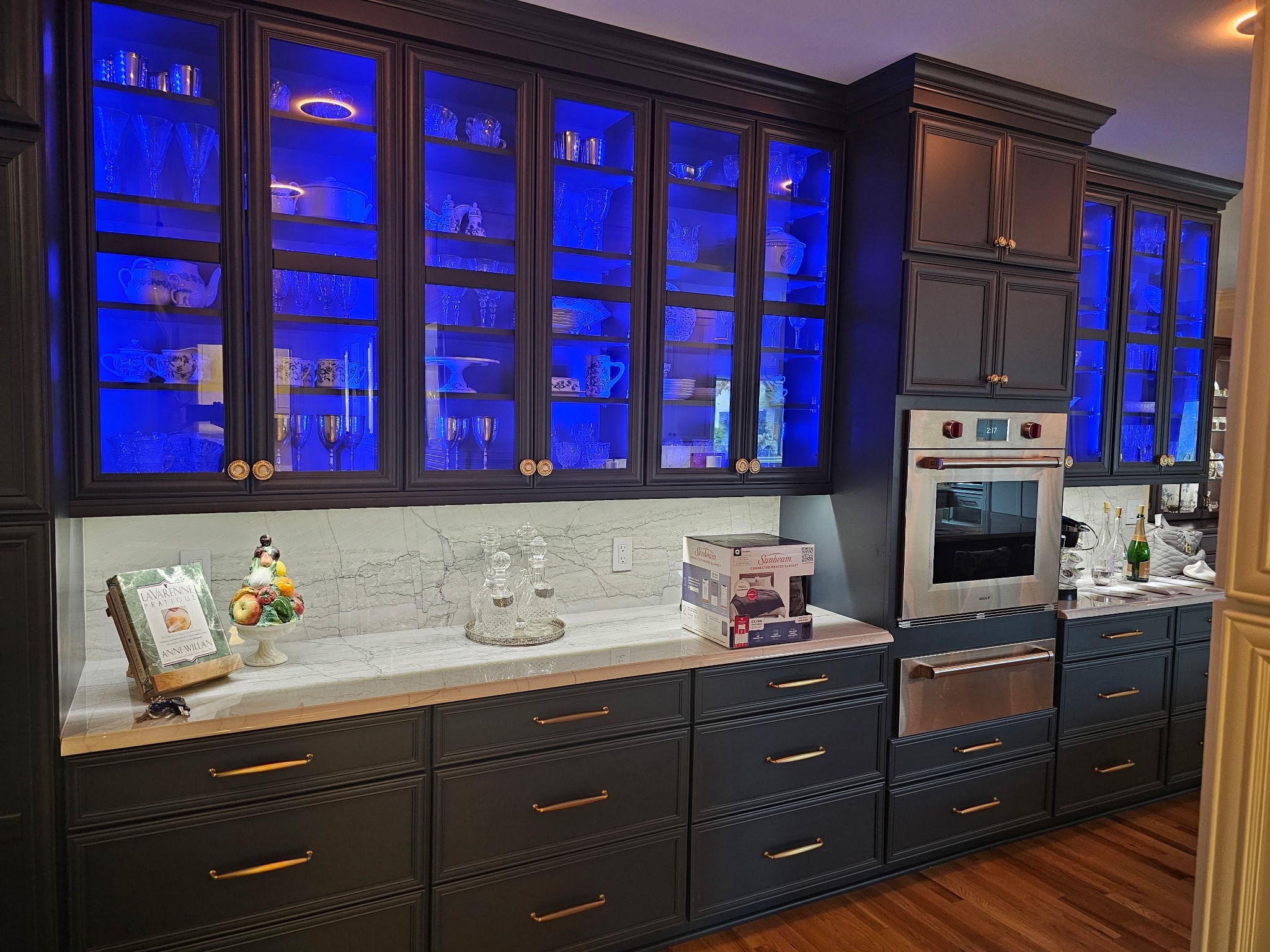 Modern kitchen renovation featuring blue lit glass cabinets