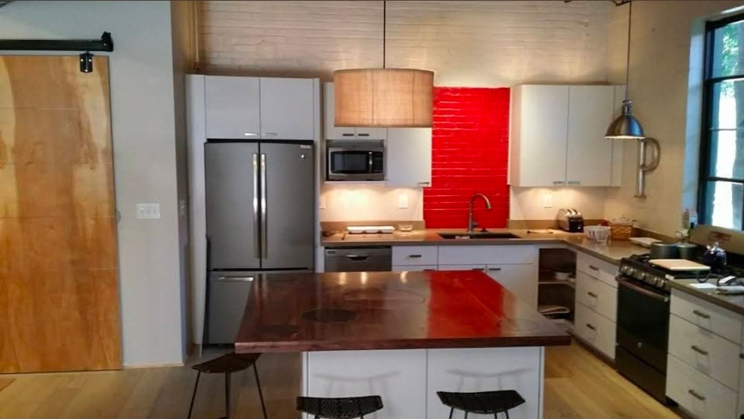 Modern kitchen remodel with red brick backsplash and island counter