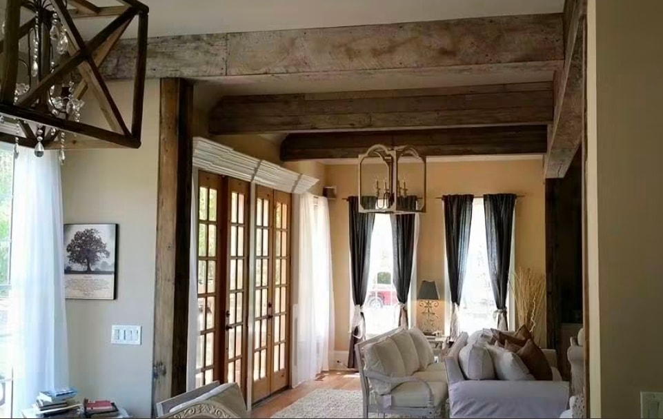 Rustic bedroom renovation with exposed wooden beams and custom curtains